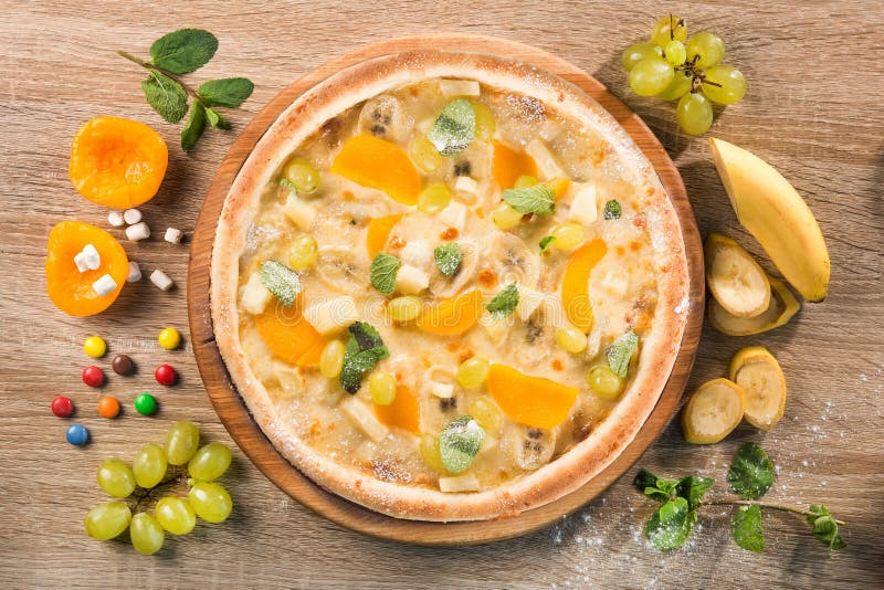 Sweet pizza with fruit, banana, grapes and orange