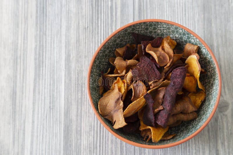 Sweet potato, beetroot and parsnip crisps chips in a patterned bowl. stock images