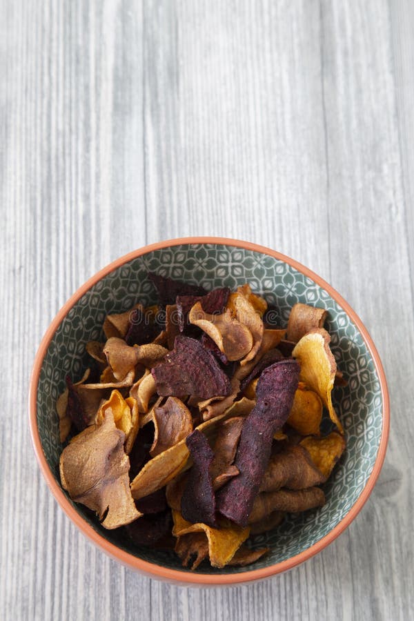 Sweet potato, beetroot and parsnip crisps chips in a patterned bowl. royalty free stock image