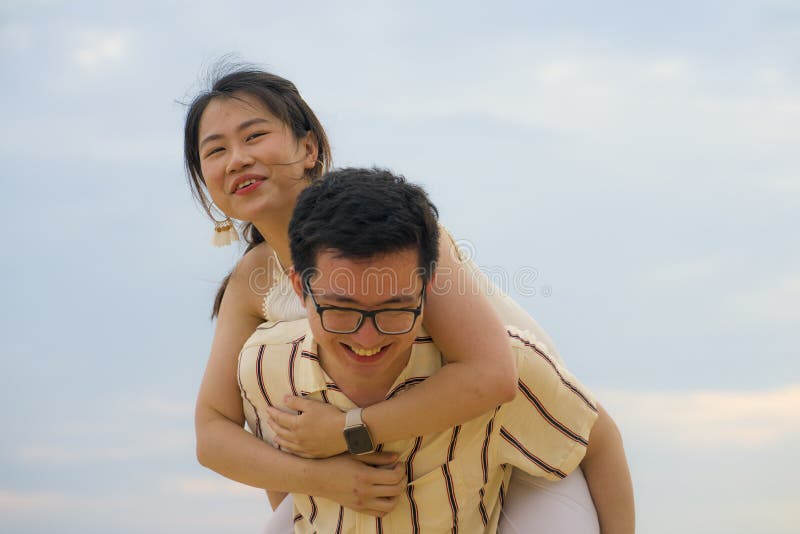 Sweet and romantic lifestyle portrait of young happy Asian Chinese couple in love enjoying holiday or weekend with man carrying stock images Sweet and romantic lifestyle portrait of young happy Asian Chinese couple in love enjoying holiday or weekend with man carrying stock images