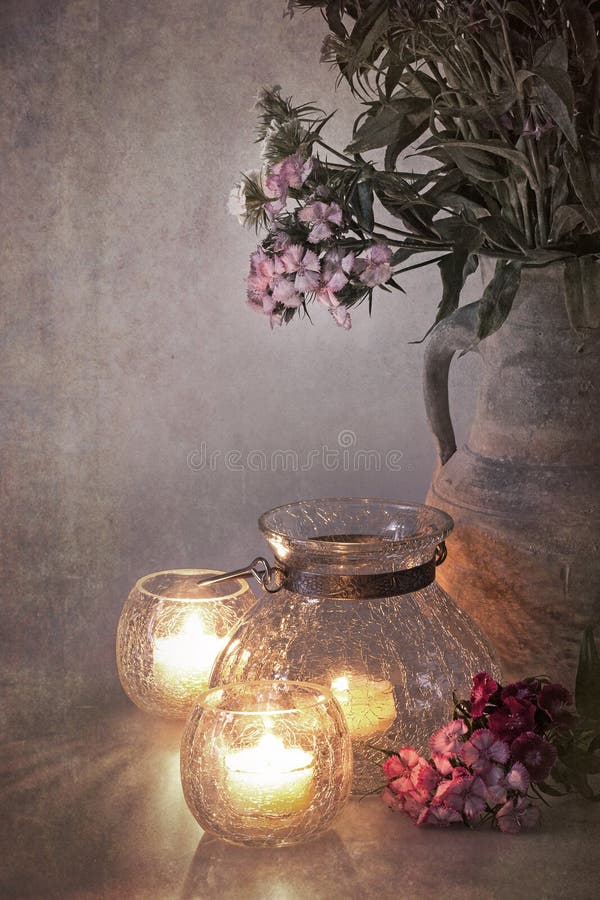 A vase of Sweet Williams by candlelight. Nostalgic, vintage effect with faded colours in style of early hand-painted photographs. A vase of Sweet Williams by candlelight. Nostalgic, vintage effect with faded colours in style of early hand-painted photographs.