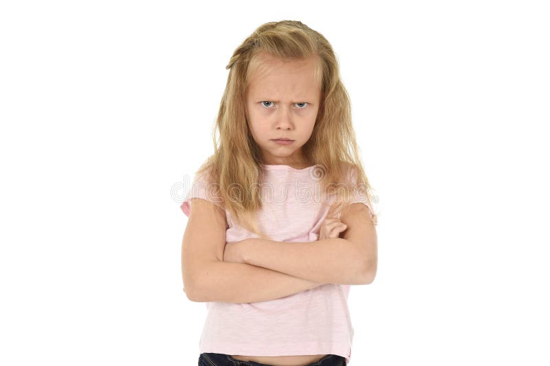 Cute and sweet young schoolgirl with blond hair and folded arms looking angry and upset in frustrated and unhappy face expression in child education and emotions concept isolated white background. Cute and sweet young schoolgirl with blond hair and folded arms looking angry and upset in frustrated and unhappy face expression in child education and emotions concept isolated white background