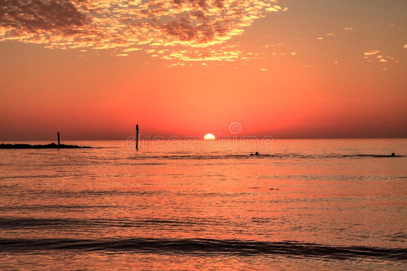 Swim at sunset with a red sky over South Marco Island Beach stock photos Swim at sunset with a red sky over South Marco Island Beach stock photos