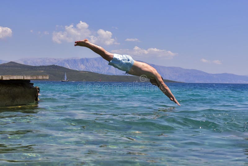 Man swimmer jumping to sea water