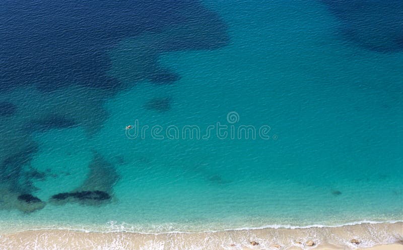 A solitary swimmer paddles in the Mediterranean sea. A solitary swimmer paddles in the Mediterranean sea.