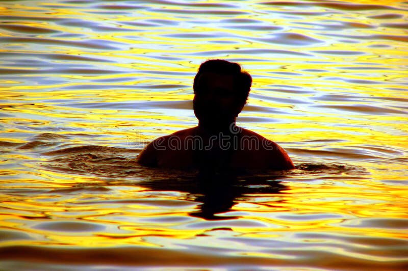 Silhouette of a swimmer in water at sunset. Silhouette of a swimmer in water at sunset