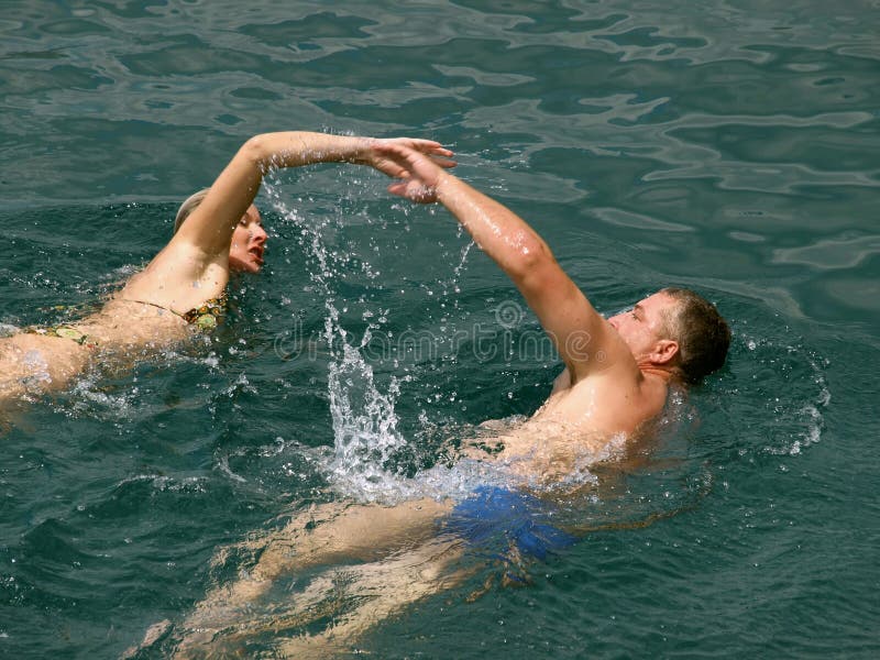 Man and woman (husband and wife - best frineds) together swim at holidays in the blue Adriatic sea (Croatia-Dalmatia). Horizontal color photo. Man and woman (husband and wife - best frineds) together swim at holidays in the blue Adriatic sea (Croatia-Dalmatia). Horizontal color photo.