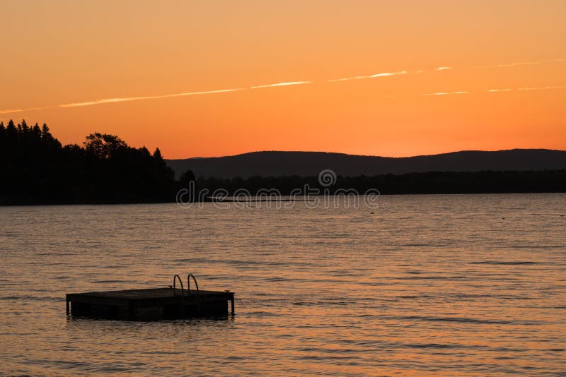 Swimming float and lake in Vermont at sunset