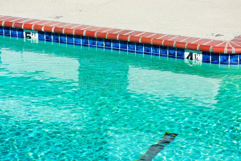 Swimming pool depth markers identify the water depth for swimmers. Four and one half feet, and five feet depth signs.