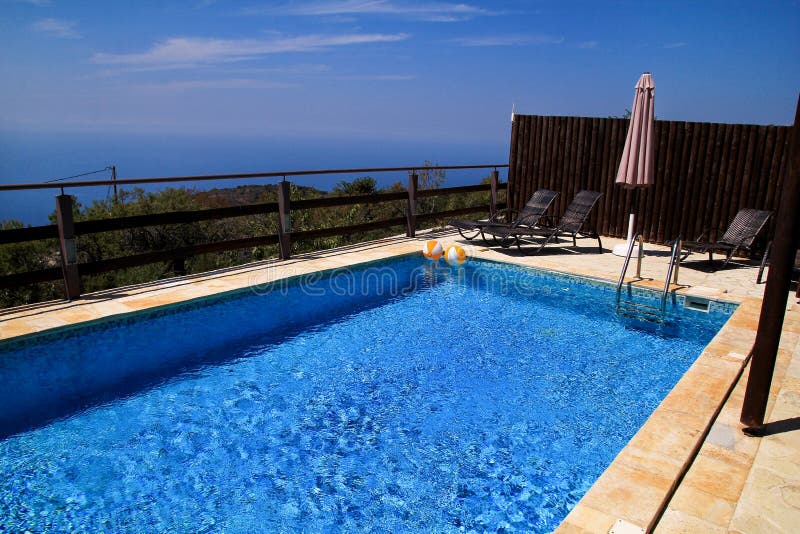 Swimming pool of luxury holiday villa, amazing nature view landscape sea. Relax near swimming pool with handrail, deck chairs. royalty free stock image Swimming pool of luxury holiday villa, amazing nature view landscape sea. Relax near swimming pool with handrail, deck chairs. royalty free stock image