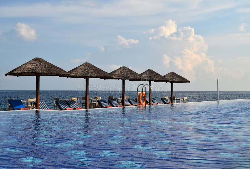 Swimming Pool with Sunchairs and Natural Umbrellas stock image Swimming Pool with Sunchairs and Natural Umbrellas stock image