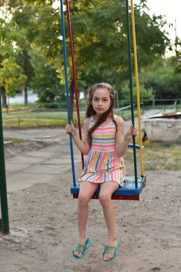 Swing ride - swinging girl. Girl riding a swing