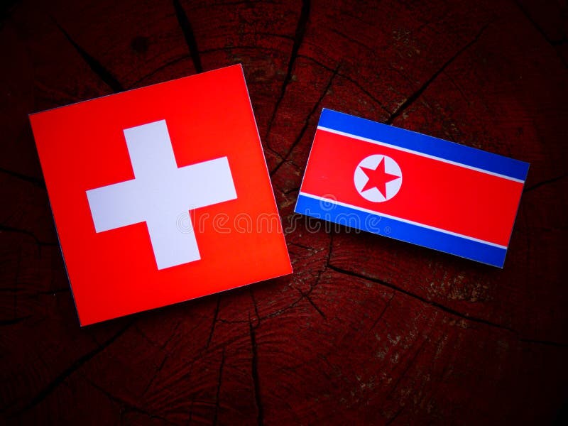 Swiss Flag with North Korean Flag on a Tree Stump Stock Photo Image