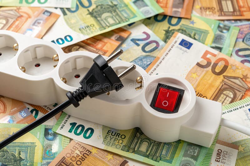 Switched off white power strip and unplugged black electric plug over euro banknotes background. Inflation and power crisis stock photography