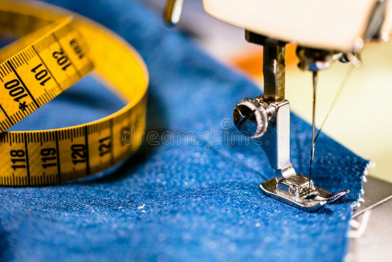 Sy grov bomullstvilljeans med symaskinen Reparationsjeans vid symaskinen Förändringsjeans som fållar ett par jeans som är handgjo royaltyfria foton Sy grov bomullstvilljeans med symaskinen Reparationsjeans vid symaskinen Förändringsjeans som fållar ett par jeans som är handgjo royaltyfria foton