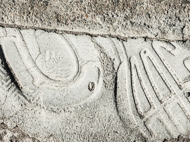 Foot prints from the shoe which is stamped ADIDAS shoe brand logo on the surface of a footpath in Sydney. stock photos Foot prints from the shoe which is stamped ADIDAS shoe brand logo on the surface of a footpath in Sydney. stock photos