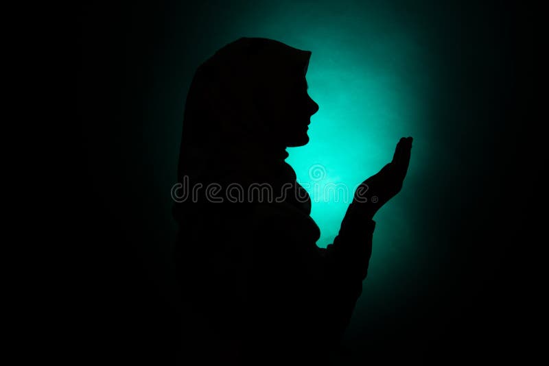 Silhouette of a muslim woman praying to Allah. Silhouette of a muslim woman praying to Allah