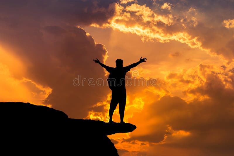 Silhouette man backpacker standing raised up arms achievements successful and celebrate success on top of the mountain in sunset. Silhouette man backpacker standing raised up arms achievements successful and celebrate success on top of the mountain in sunset.