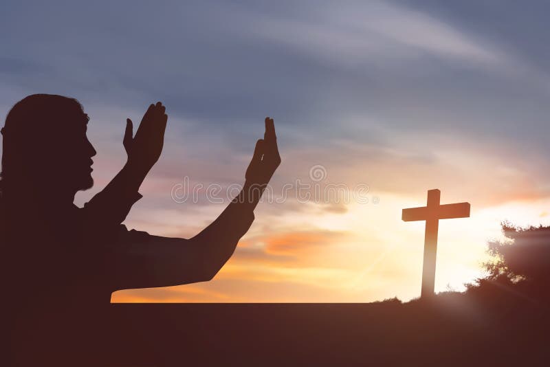 Sylwetka mężczyzna dźwigania ręka podczas gdy ono modli się Jesus zdjęcie stock Sylwetka mężczyzna dźwigania ręka podczas gdy ono modli się Jesus zdjęcie stock