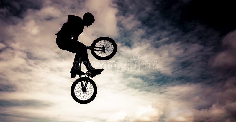 Silhouette of a man doing an jump with a bmx bike. Color toned image. Silhouette of a man doing an jump with a bmx bike. Color toned image.