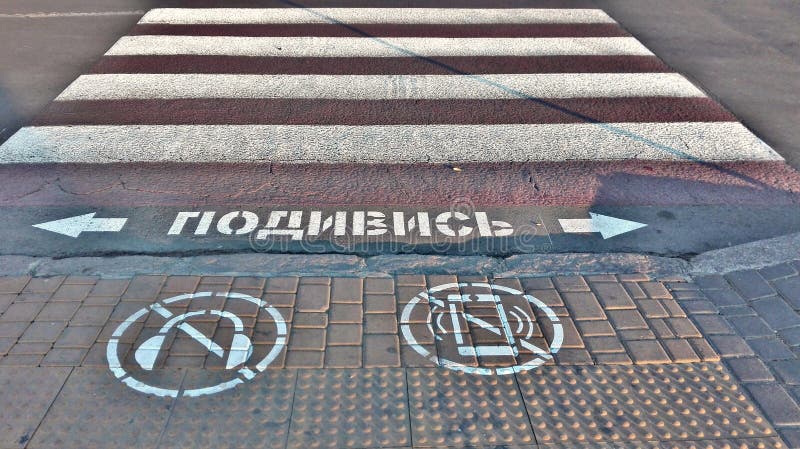 Symbol av förbud som ser mobiltelefonen och att lyssna till musik med hörlurar, medan korsa vägen arkivfoton Symbol av förbud som ser mobiltelefonen och att lyssna till musik med hörlurar, medan korsa vägen arkivfoton