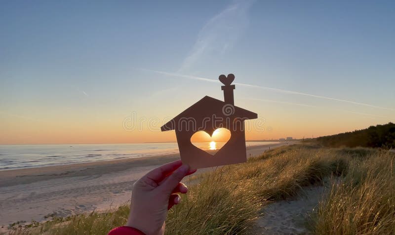 Symbol home, family comfort. Concept building beach house family, hands holding paper house stock footage