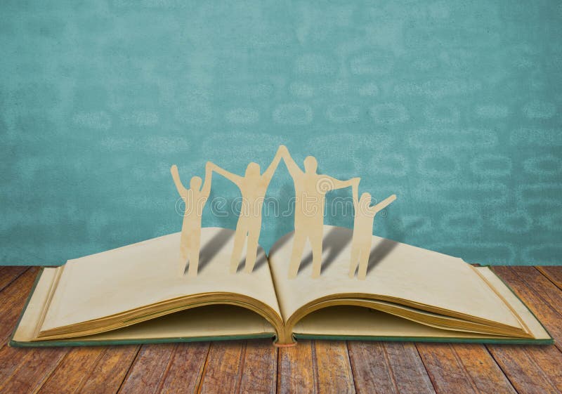 Symbole de famille de coupe de papier sur le vieux livre photographie stock Symbole de famille de coupe de papier sur le vieux livre photographie stock