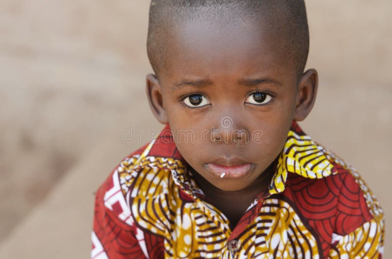 Symbole de l'Afrique de faim - petit garçon africain avec du riz sur la bouche