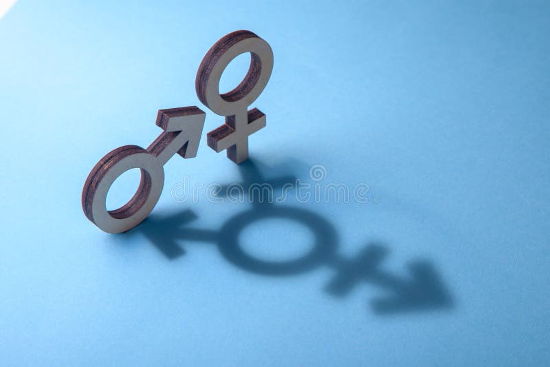 Symbols of man and woman cast shadow in the form of transgender on blue