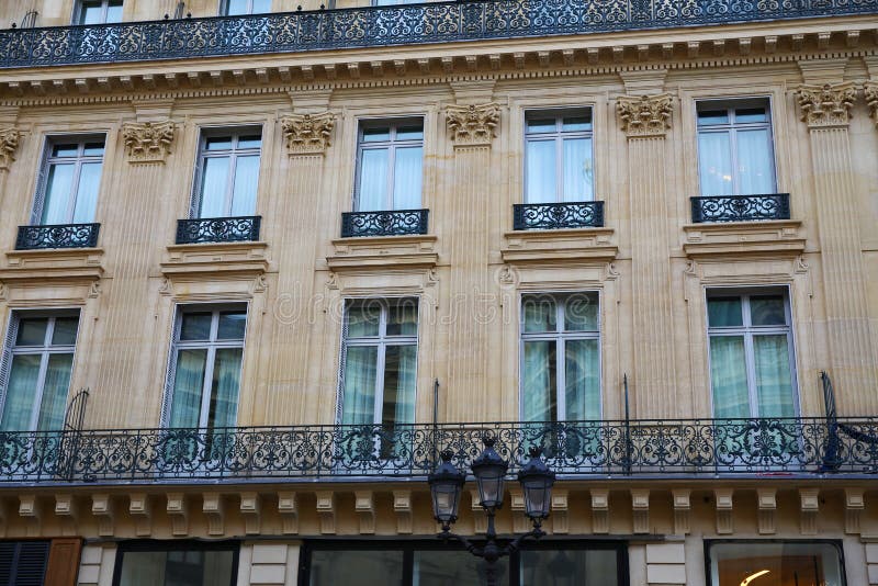 Symmetrische Architektur und kleine lange Balkone in Paris. stockbilder