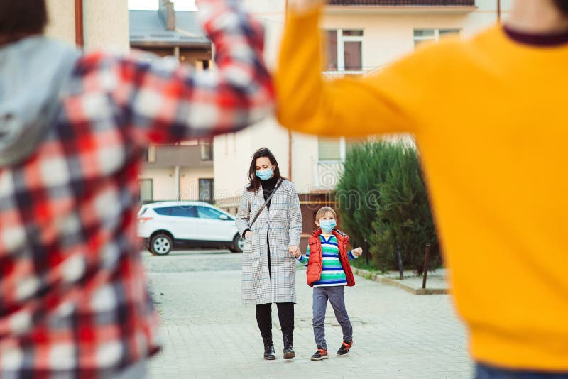 Prevention coronavirus. Family in safety mask outdoors. Coronavirus quarantine. Peple bump elbows on the street. Social distancing. Elbow bump. New greeting style. Coronavirus epidemic. Health care concept. Prevention coronavirus. Family in safety mask outdoors. Coronavirus quarantine. Peple bump elbows on the street. Social distancing. Elbow bump. New greeting style. Coronavirus epidemic. Health care concept