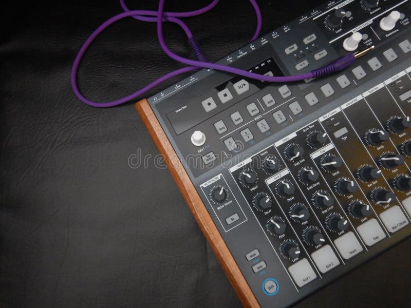 Synthesizer on black leather background with purple patch cable stock photos
