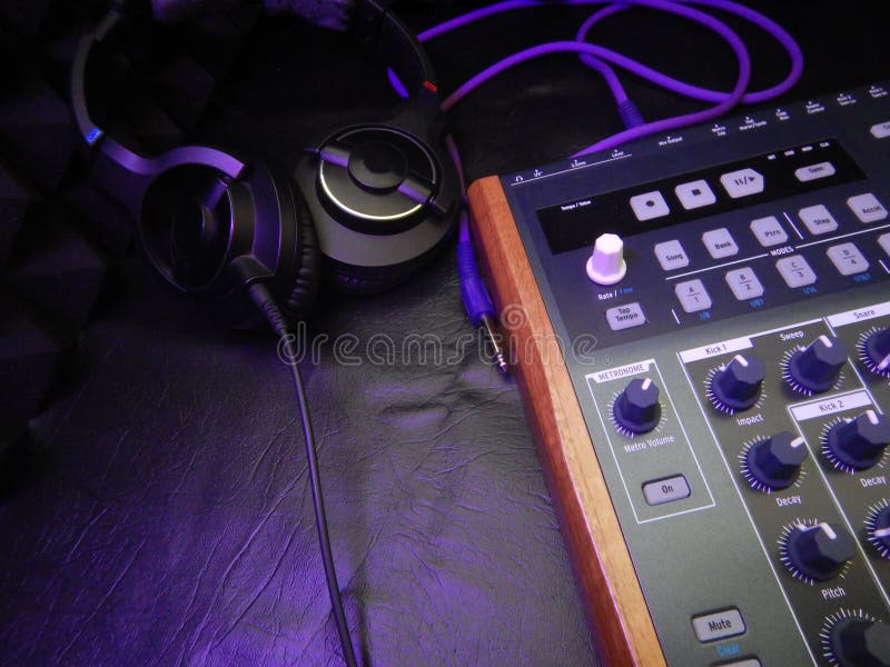 Synthesizer with headphones on black leather background with purple patch cable royalty free stock photo