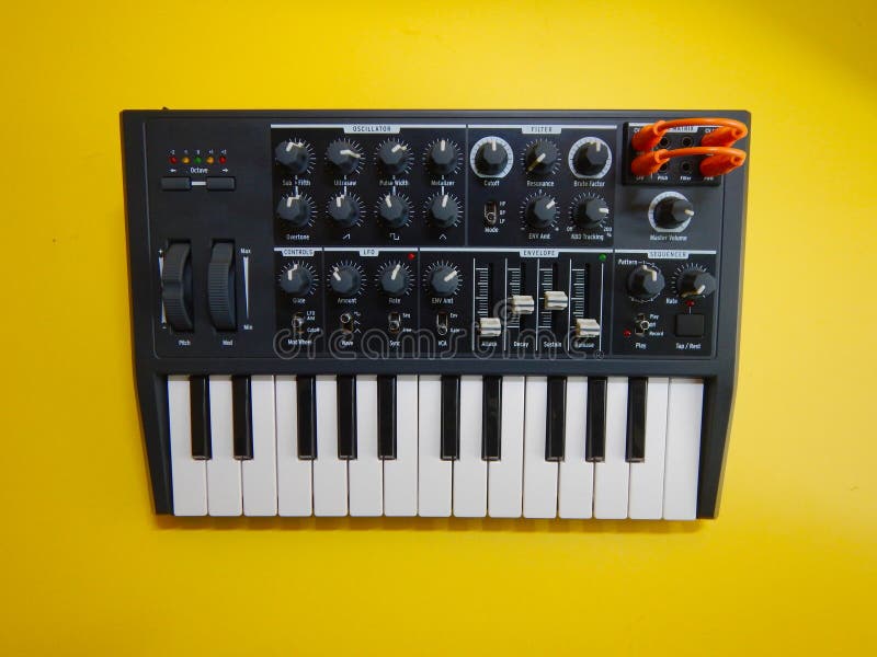 Synthesizer on yellow background with orange patch cables stock images