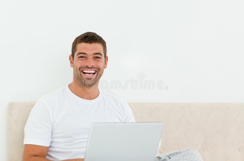 sypialnia szczęśliwa jego laptopu mężczyzna działanie obrazy stock sypialnia szczęśliwa jego laptopu mężczyzna działanie obrazy stock