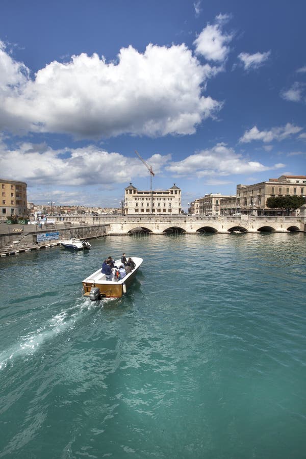 Syracuse, Italia Un barco cruza el canal en la ciudad imagen de archivo libre de regalías Syracuse, Italia Un barco cruza el canal en la ciudad imagen de archivo libre de regalías