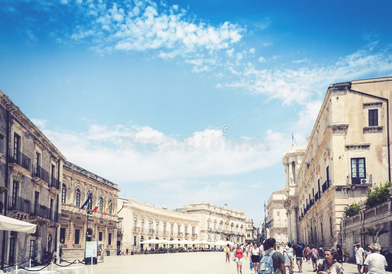 Syracuse Siracusa, Sicilia, Italia – 12 de agosto de 2018: Turistas que caminan en Piazza cuadrada antigua del Duomo con los edif imagen de archivo Syracuse Siracusa, Sicilia, Italia – 12 de agosto de 2018: Turistas que caminan en Piazza cuadrada antigua del Duomo con los edif imagen de archivo