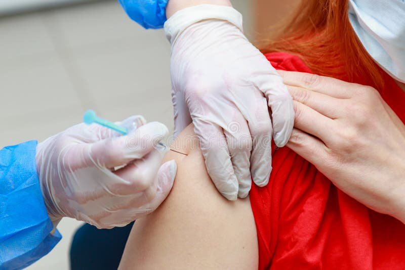 Syringe injection process on real coronavirus vaccination. Fighting the covid-19 pandemic. Selective focus , toned stock photo