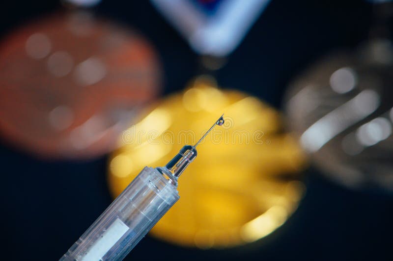 Syringe and medal set in background. Doping and drugs in sport, concept photo. Black background. High Quality Photo. Natural Light