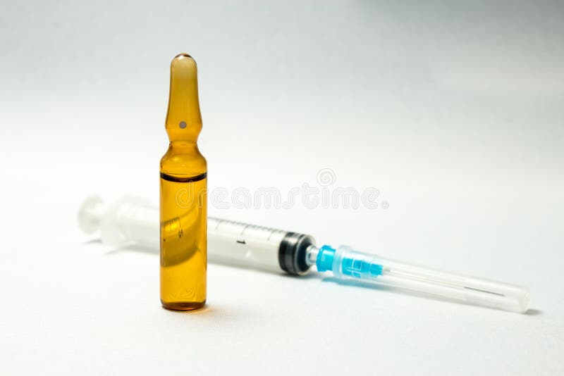 Syringe near brown glass vial stock photography