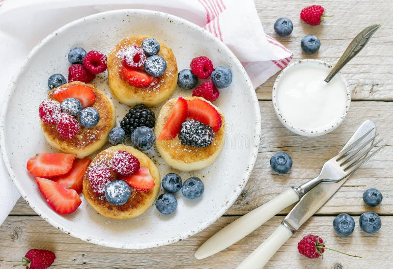 Syrniki Pancake della ricotta, syrniki, frittelle della cagliata con le bacche fresche immagini stock libere da diritti Syrniki Pancake della ricotta, syrniki, frittelle della cagliata con le bacche fresche immagini stock libere da diritti