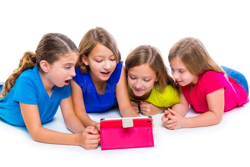 Sisters cousins kid girls with tech tablet pc playing happy lying on white background. Sisters cousins kid girls with tech tablet pc playing happy lying on white background