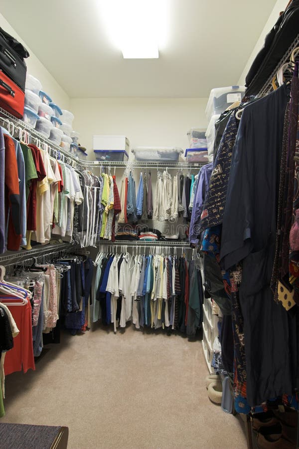 Large fully stocked walk in closet with racks of clothing. Large fully stocked walk in closet with racks of clothing