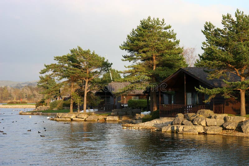 Wooden chalets among the trees at the edge of a lake. Wooden chalets among the trees at the edge of a lake