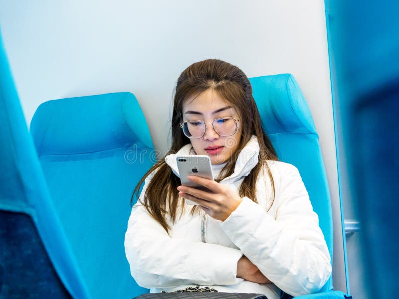 SZANGHAJ, CHINY 13 MARZEC 2019 - młoda Chińska kobieta przewodzi Pudong zawody międzynarodowi używa Jabłczanego iphone na Maglev obraz royalty free SZANGHAJ, CHINY 13 MARZEC 2019 - młoda Chińska kobieta przewodzi Pudong zawody międzynarodowi używa Jabłczanego iphone na Maglev obraz royalty free