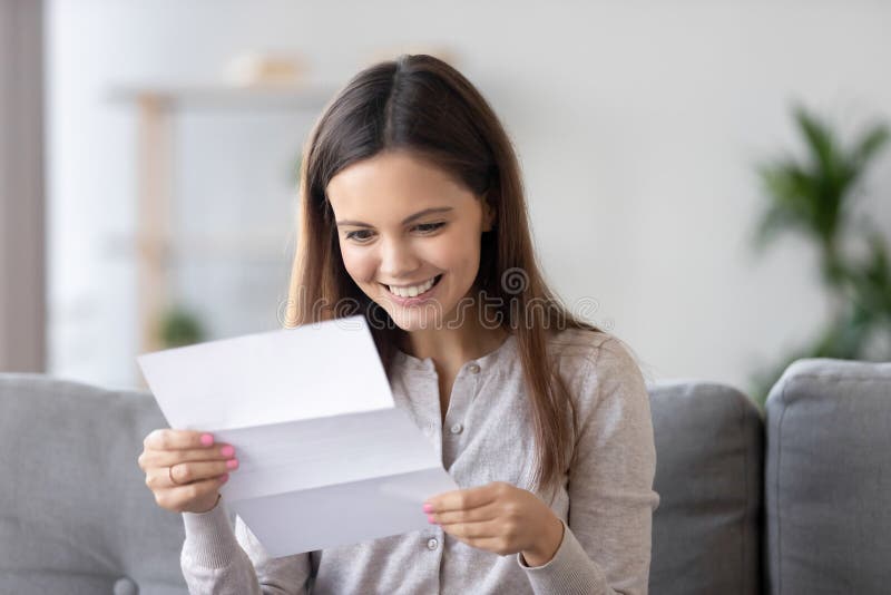 Szczęśliwy uśmiechnięty kobiety czytania papieru list, otrzymywa dobre wieści w domu