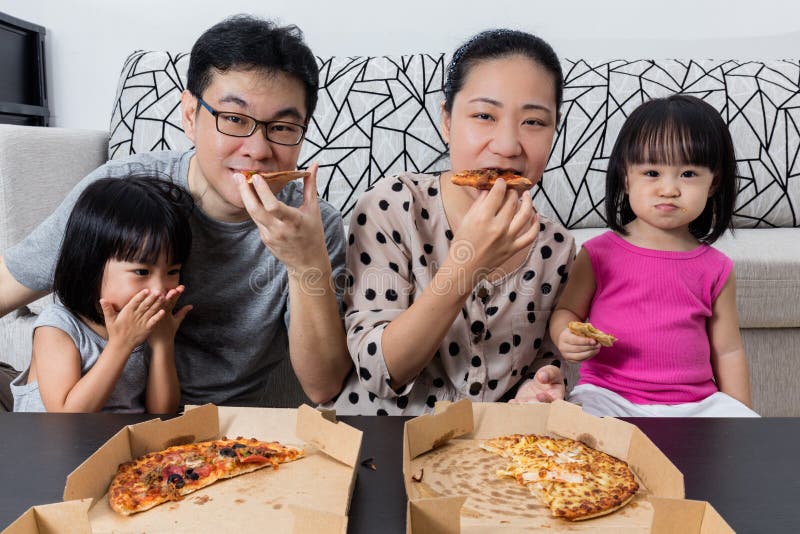 Szczęśliwa Azjatycka Chińska Rodzinna łasowanie pizza Wpólnie obraz stock Szczęśliwa Azjatycka Chińska Rodzinna łasowanie pizza Wpólnie obraz stock
