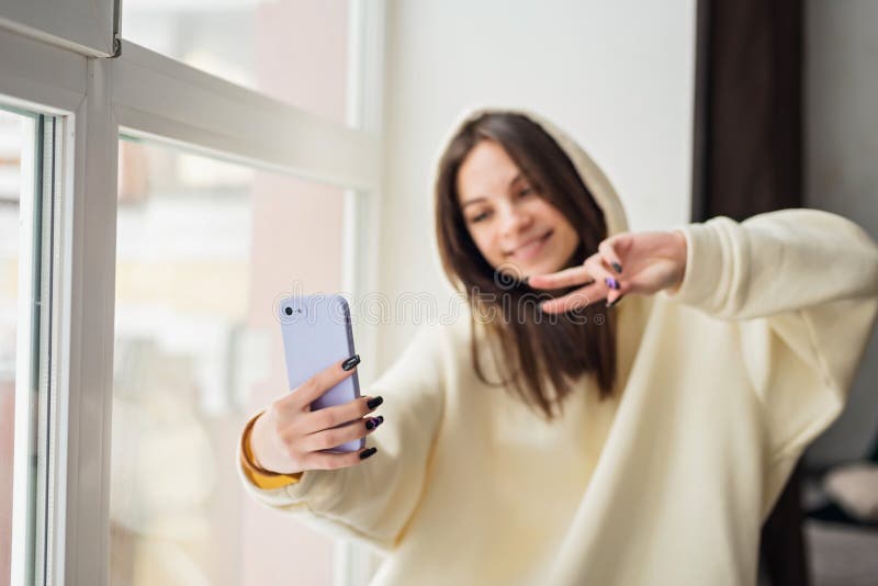 Szczęśliwa blogerka robiąca portret selfie w kamerze smartphone dla mediów społecznościowych publikując wesołą nastolatkę rozmawia fotografia stock