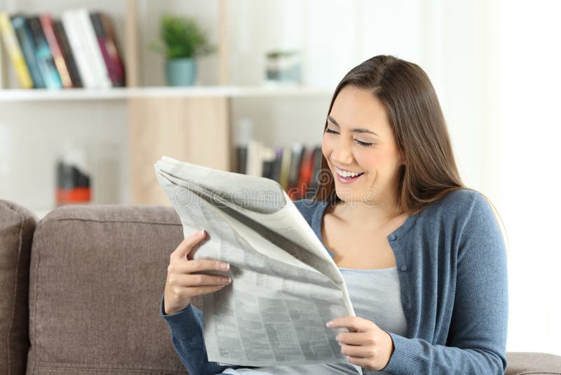 Szczęśliwa dama czyta gazetę w domu zdjęcie stock Szczęśliwa dama czyta gazetę w domu zdjęcie stock