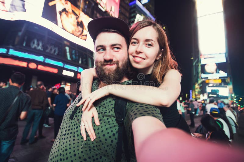 Szczęśliwa datowanie para w miłości bierze selfie fotografię na times square w Nowy Jork podczas gdy podróż w usa na miesiącu mio obraz stock Szczęśliwa datowanie para w miłości bierze selfie fotografię na times square w Nowy Jork podczas gdy podróż w usa na miesiącu mio obraz stock